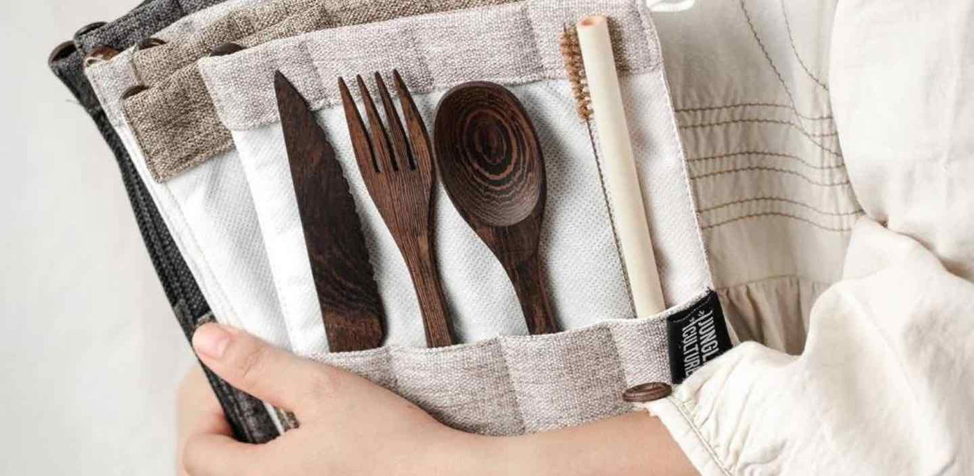 Seven Bestselling Sustainable Swaps. Picture id: Someone is holding dark wood cutlery sets